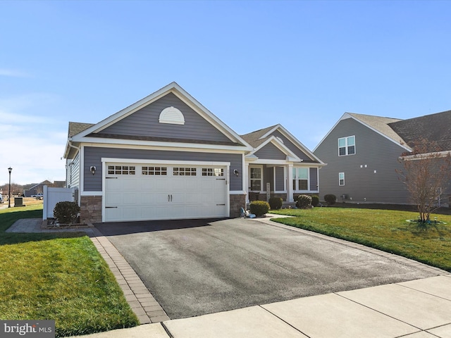 view of front of property with a front lawn, a garage, stone siding, and driveway