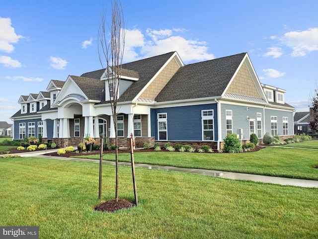 view of front of home with a standing seam roof, a front yard, and metal roof