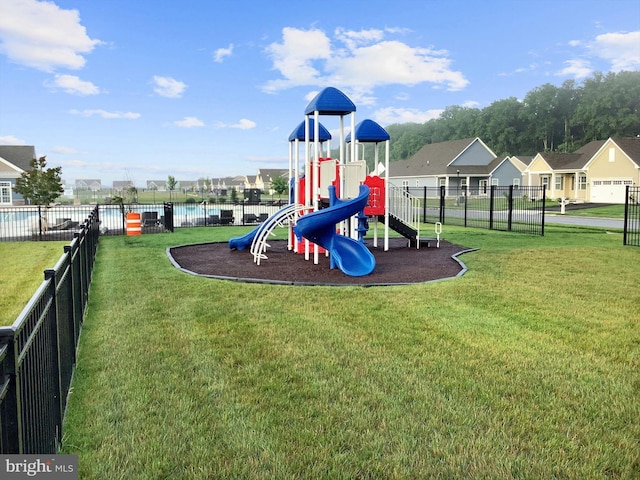 community play area with fence and a lawn