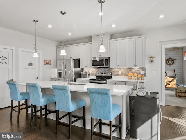 kitchen featuring a sink, stainless steel appliances, tasteful backsplash, and light countertops