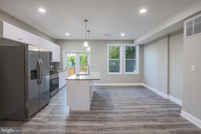 kitchen with light stone counters, a sink, white cabinetry, appliances with stainless steel finishes, and dark wood-style floors