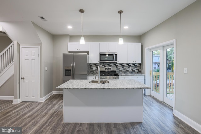 kitchen featuring a kitchen island with sink, a sink, visible vents, appliances with stainless steel finishes, and decorative backsplash