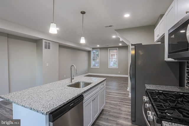 kitchen with visible vents, white cabinets, dark wood-style floors, appliances with stainless steel finishes, and a sink