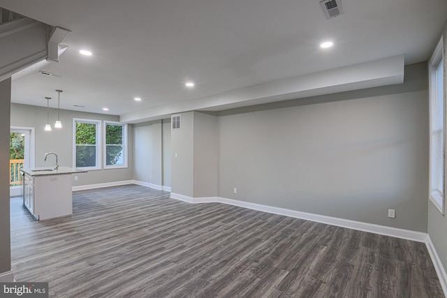 below grade area featuring dark wood-style floors, recessed lighting, visible vents, and baseboards