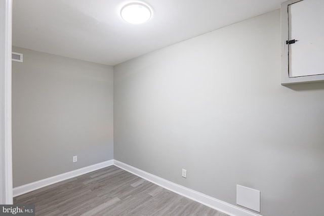 empty room featuring visible vents, baseboards, and wood finished floors