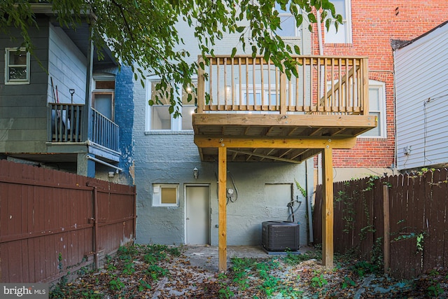 rear view of house with brick siding, fence, central AC, and stucco siding