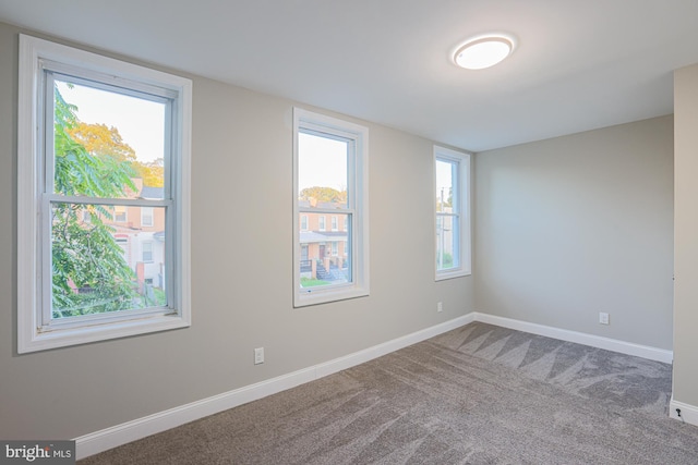 unfurnished room with carpet and baseboards