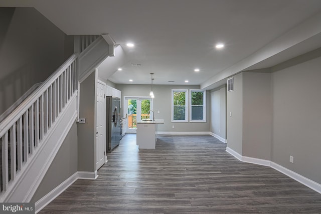 interior space with dark wood-type flooring, recessed lighting, a sink, and baseboards