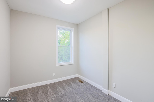 spare room with visible vents, baseboards, and carpet flooring