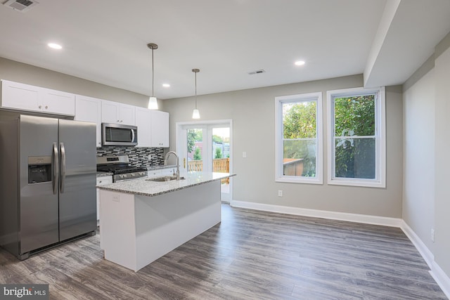 kitchen featuring stainless steel appliances, visible vents, dark wood-type flooring, and tasteful backsplash