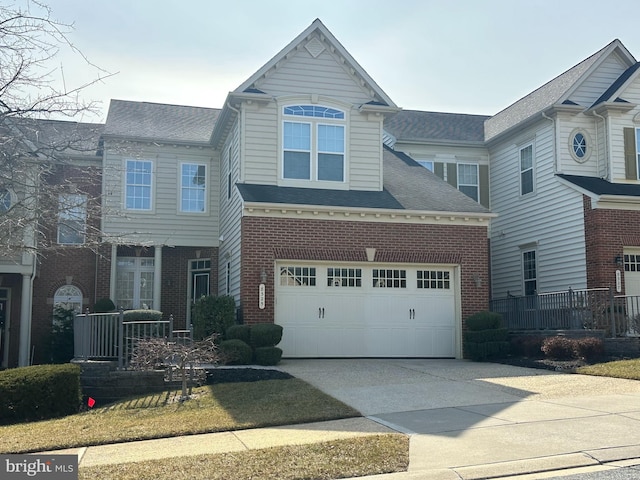 view of front of home featuring concrete driveway, brick siding, and roof with shingles