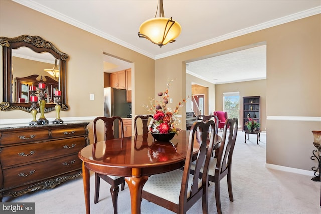 dining space with baseboards, light carpet, and crown molding