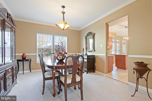 dining area featuring ornamental molding, baseboards, and light carpet