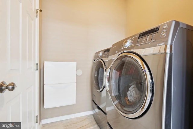 laundry room featuring laundry area, baseboards, and separate washer and dryer