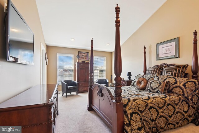 bedroom with light colored carpet and vaulted ceiling