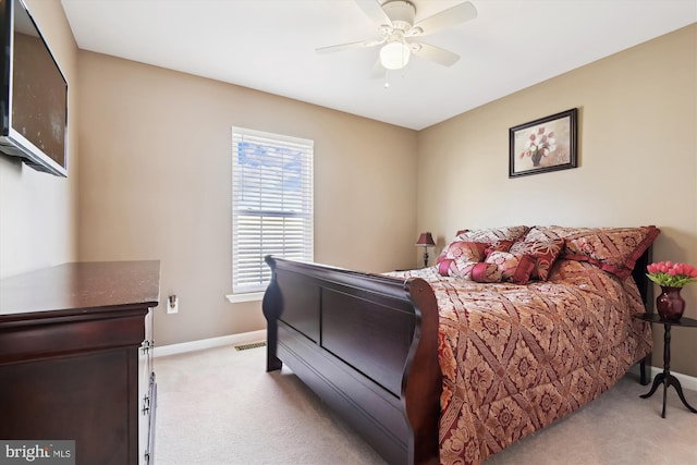 bedroom with a ceiling fan, visible vents, light colored carpet, and baseboards