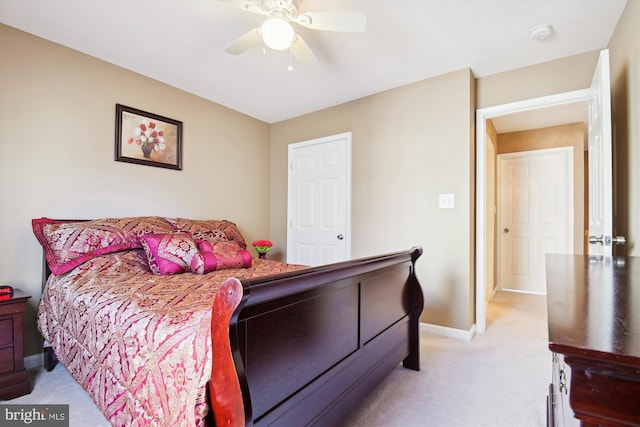 bedroom featuring baseboards, light colored carpet, and ceiling fan