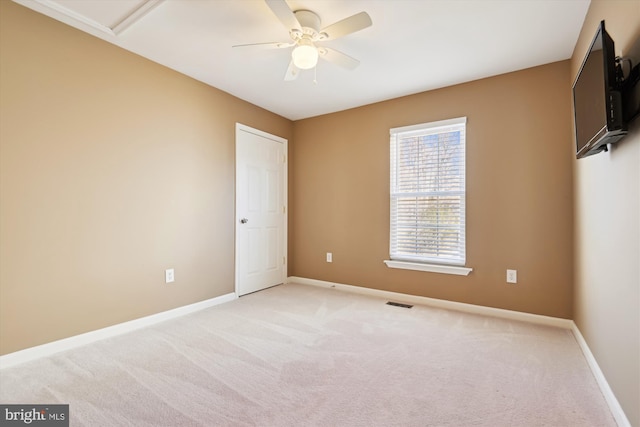 unfurnished room featuring visible vents, light colored carpet, baseboards, and ceiling fan