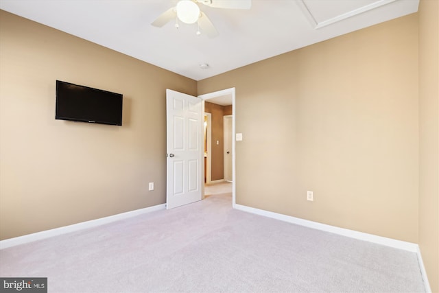 spare room with light colored carpet, baseboards, and ceiling fan