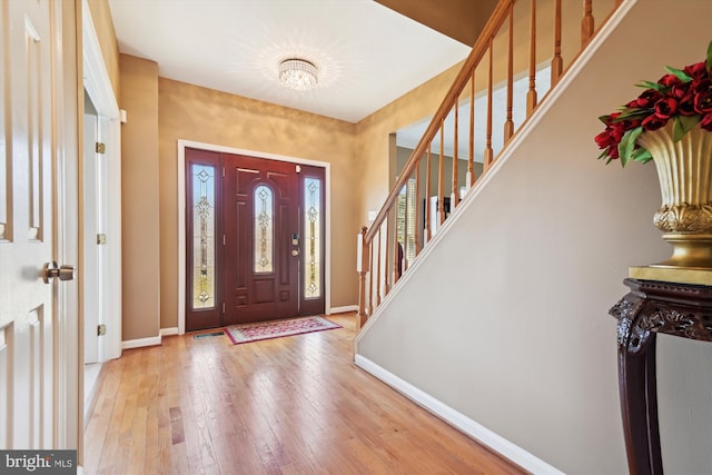 entrance foyer with stairs, hardwood / wood-style flooring, visible vents, and baseboards