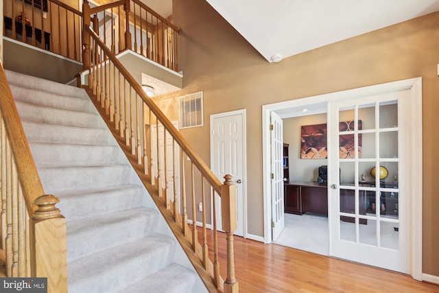 stairs with wood finished floors, visible vents, and baseboards