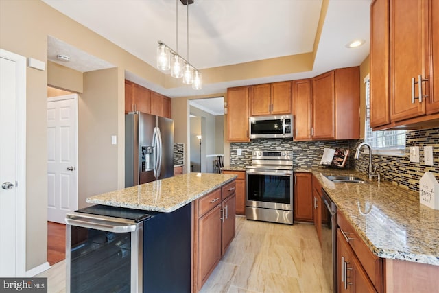 kitchen featuring wine cooler, brown cabinetry, stainless steel appliances, a raised ceiling, and a sink