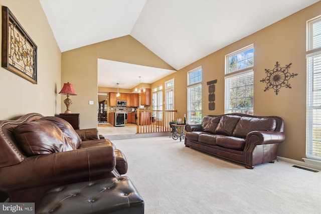 living room with visible vents, high vaulted ceiling, baseboards, and carpet floors