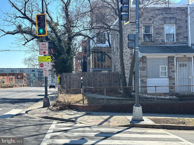 view of street with sidewalks, traffic lights, traffic signs, and curbs