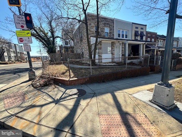 exterior space with stone siding and a fenced front yard