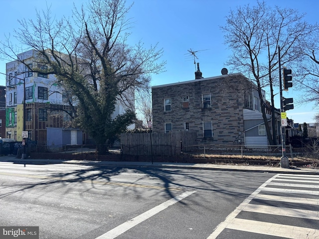 view of road with traffic lights, traffic signs, curbs, and sidewalks