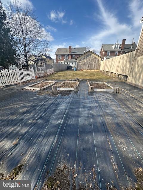 wooden terrace featuring a fenced backyard and a vegetable garden