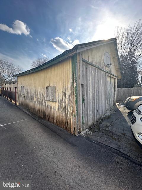 view of side of property featuring a garage and fence