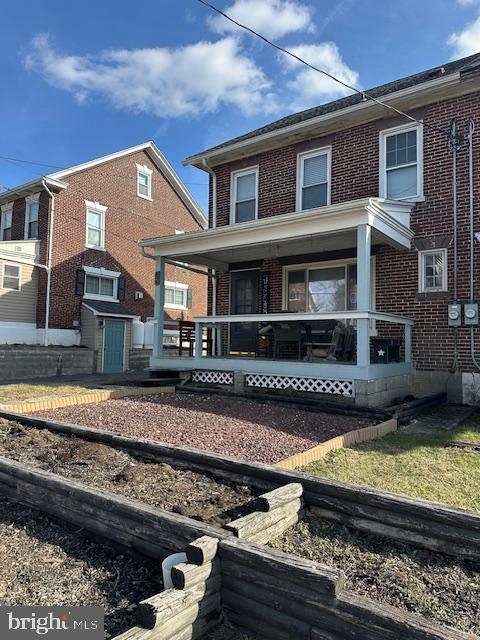 view of front of home with covered porch and brick siding