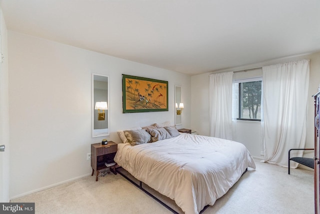 bedroom featuring light carpet and baseboards