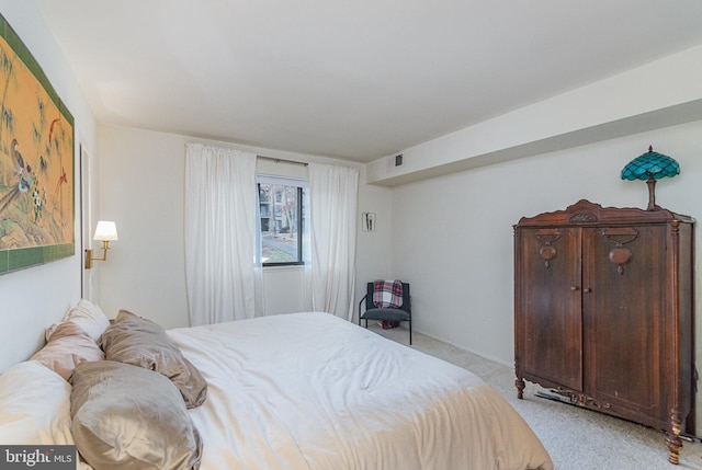 bedroom featuring visible vents and light colored carpet