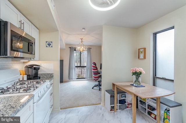 kitchen featuring white cabinets, white range with gas cooktop, marble finish floor, tasteful backsplash, and stainless steel microwave