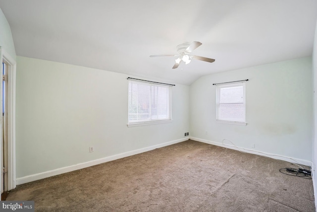 spare room with baseboards, carpet, ceiling fan, and vaulted ceiling