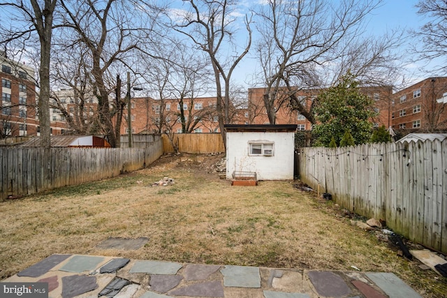 view of yard with a storage shed, a fenced backyard, and an outdoor structure