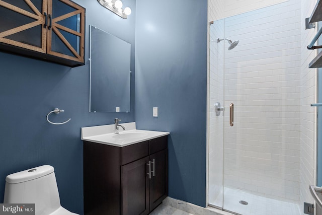 bathroom with toilet, a shower stall, baseboards, and vanity