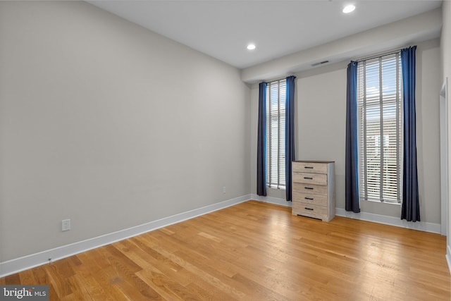 unfurnished bedroom with recessed lighting, light wood-style flooring, and baseboards