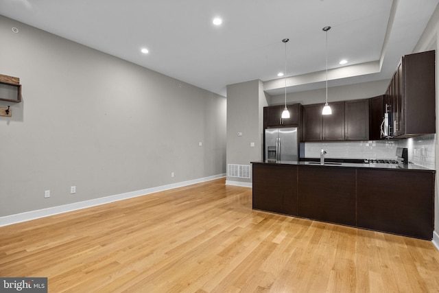 kitchen with dark brown cabinetry, visible vents, dark countertops, appliances with stainless steel finishes, and a sink