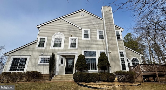 view of front of house with a chimney and a wooden deck