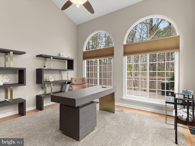 office featuring high vaulted ceiling, baseboards, a ceiling fan, and wood finished floors