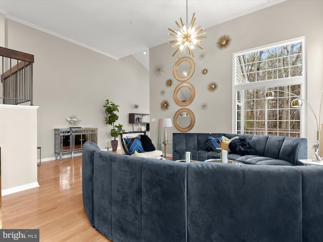 living room with crown molding, light wood-style flooring, an inviting chandelier, high vaulted ceiling, and baseboards