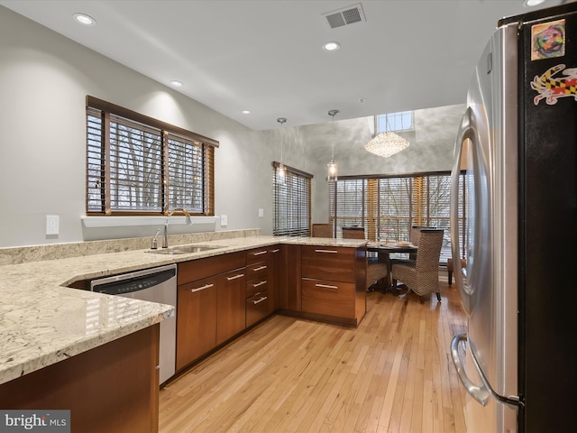 kitchen with a sink, visible vents, a healthy amount of sunlight, appliances with stainless steel finishes, and light wood finished floors