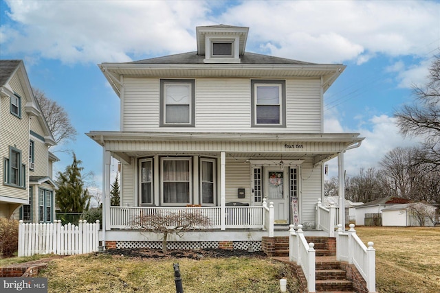 american foursquare style home with covered porch, fence, and a front lawn