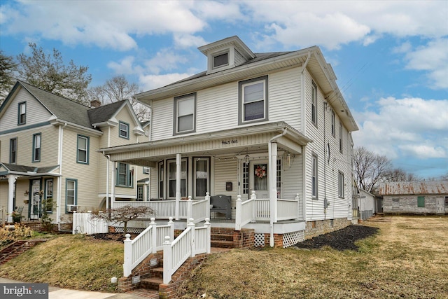 american foursquare style home with covered porch and a front lawn