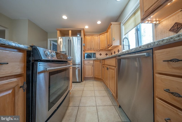 kitchen featuring light tile patterned floors, appliances with stainless steel finishes, light stone countertops, light brown cabinetry, and recessed lighting