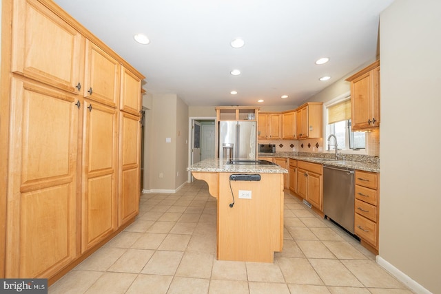 kitchen featuring light stone countertops, appliances with stainless steel finishes, a breakfast bar, and a center island