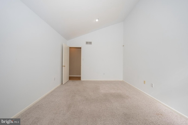 empty room featuring light carpet, high vaulted ceiling, and baseboards